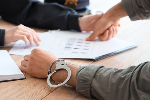 man at a police station being fingerprinted and in need of a murder defense lawyer at The Law Offices of Jeffrey Jackson in Nashville Tennessee.