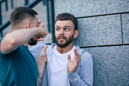 A man threatening another man symbolizes assault charges in Tennessee.