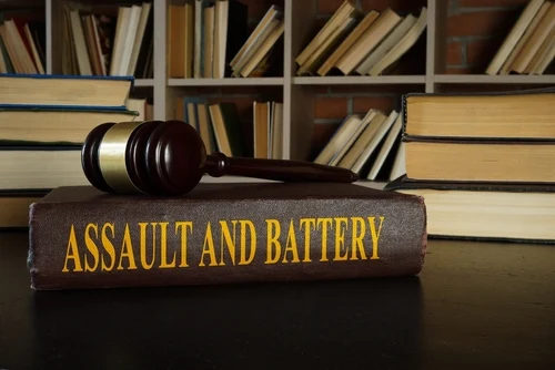 law book about assault and battery with judge gavel